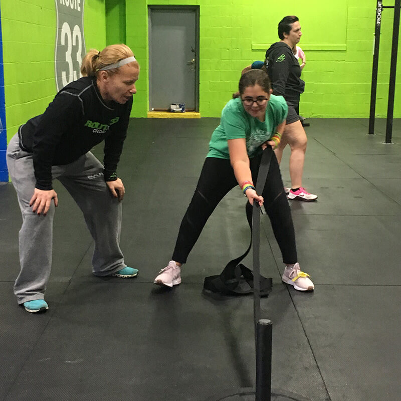 Girl pulling weighted sled